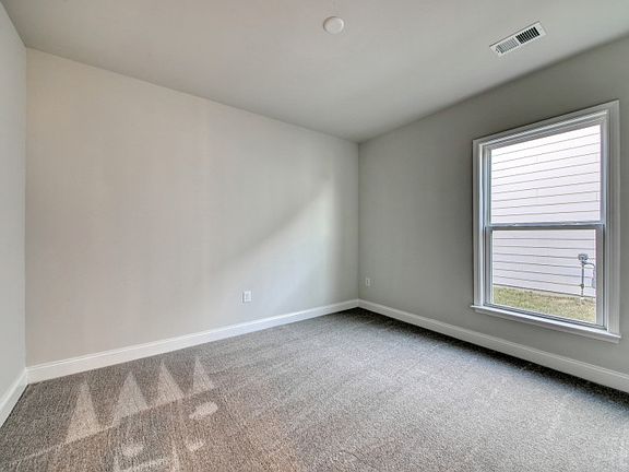 Multi-purpose Flex Room with a large window bringing in soft natural light.