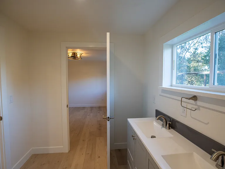 Spacious bathroom with double vanity and beautiful views to trees and distance hills.
