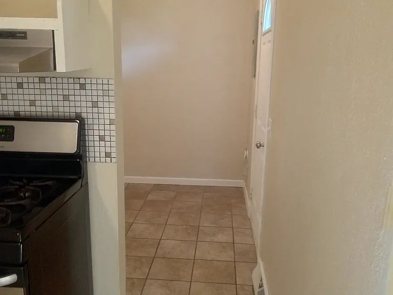 Kitchen into the utility room where the washer and dryer hooks up are and back door.