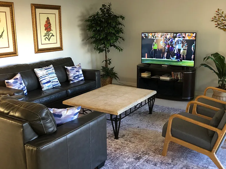 Living room with comfortable seating for 7 and 55" HDTV. Couch opens to a queen sofa bed.