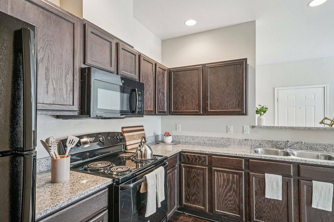 This bright kitchen at Walnut Grove apartments features granite countertops and natural light.