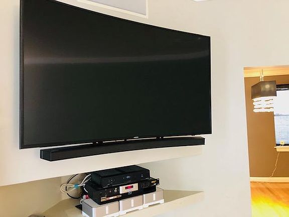 Includes use of Samsung Curved 55' 4K TV (Living Room); Dining Room in background on the left