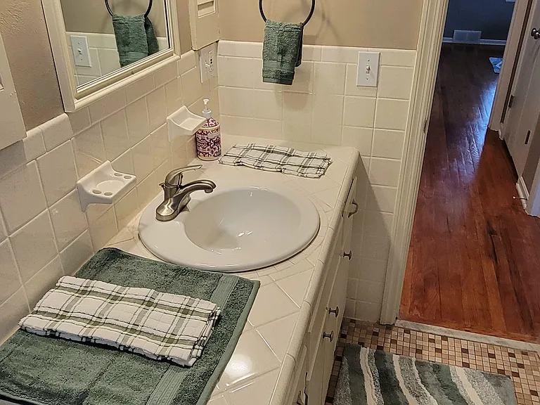 Unwind and relax in the quiet restroom area with new towels, shower curtain, rug and decor