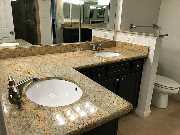 Master bath with dual sinks, granite counters and a full length mirrored door to the closet.