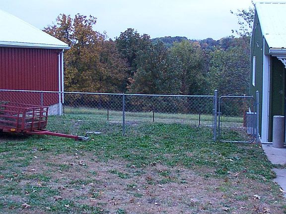 Animal pen between and under shed