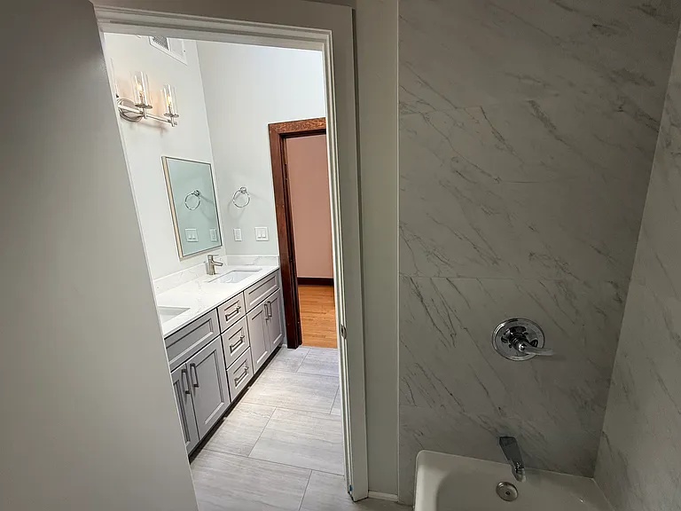 Hallway Bathroom #1 has 2 sinks and a bathtub.