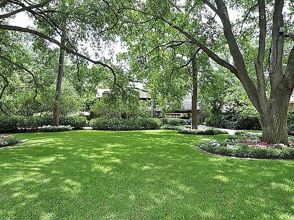 Expansive front yard with beautiful mature trees, sprinkler system and landscape lighting.