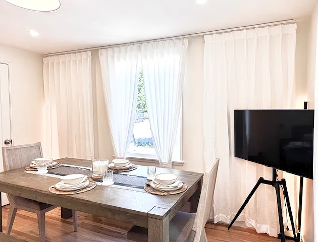 Farmhouse style dining room with tasteful furniture and multiple light sources.