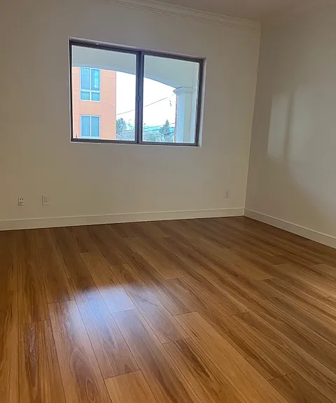 Bedroom with big picture window overlooking the private balcony on Lewis St