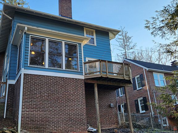 Back of house with floor to ceiling windows in breakfast nook.