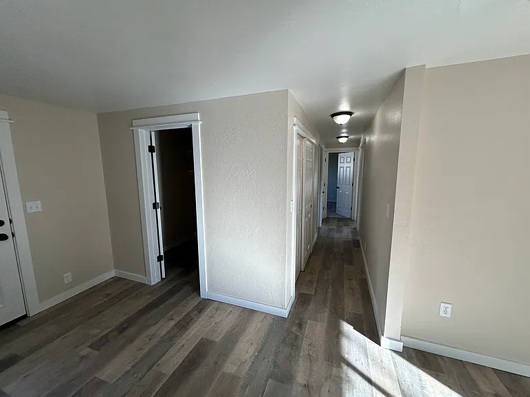 Dining space by kitchen, view of laundry room door, hallway to bedrooms