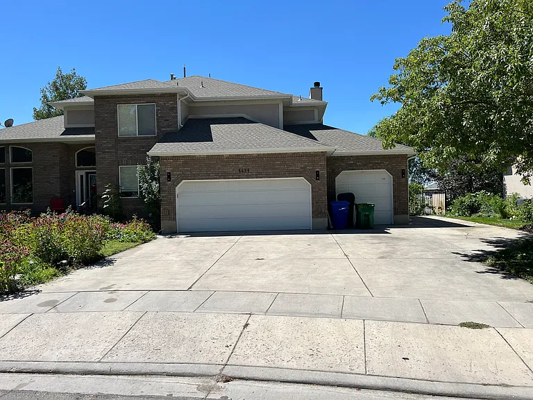 Outside view of home, apartment entrance is through a gate around the right side where the tenant parking is.