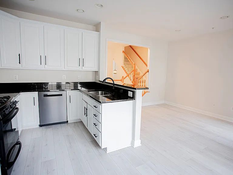 Light and Airy Breakfast Nook opening to Modern Kitchen featuring newer stainless steel appliances and a breakfast bar