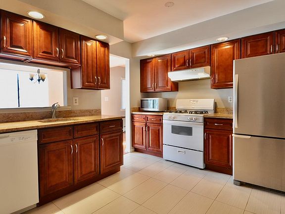 Eat-In Kitchen with Granite Counters and Pass-Through Window to Dining Room. Newer Microwave and Refrigerator.