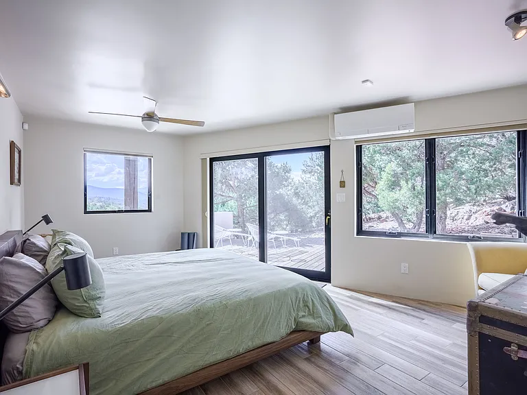 Master bedroom with lots of natural light, ceiling fan, and sliding door to private patio (also closest to the hot tub deck!)