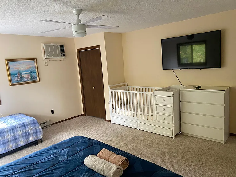 master bedroom with King Size bed, crib and large TV