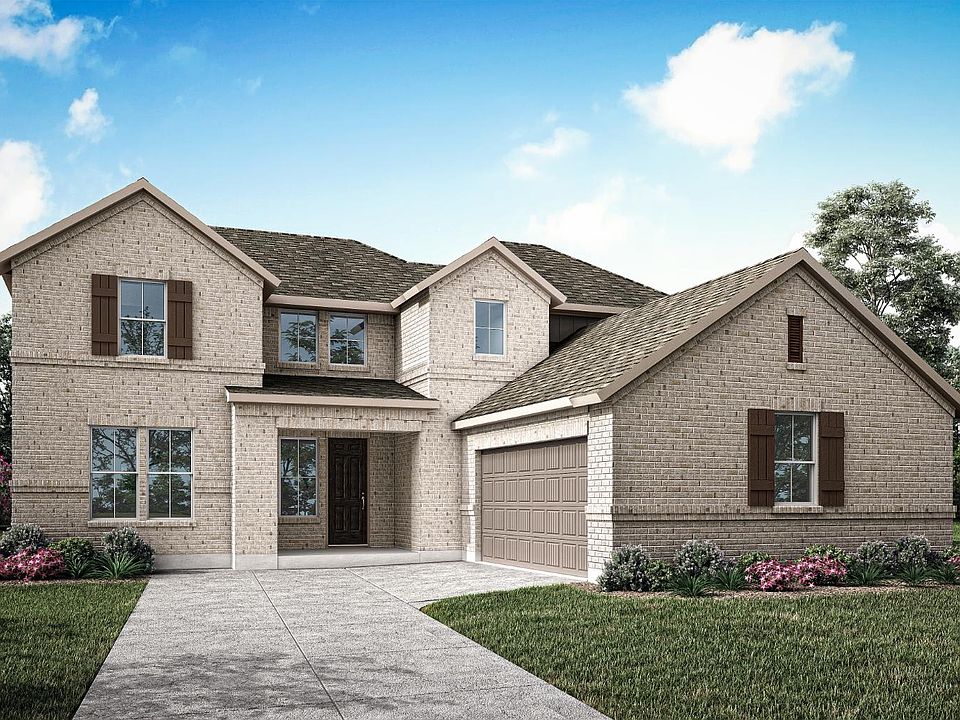 A two-story brick house with a garage, surrounded by a well-manicured lawn and landscaping, set agai