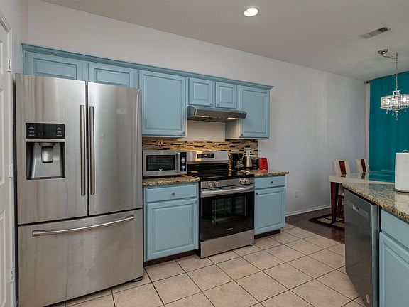 Open kitchen concept with all the major appliances with 2 bar top stools by the pass through. With the washer/dryer in laundry closet.
