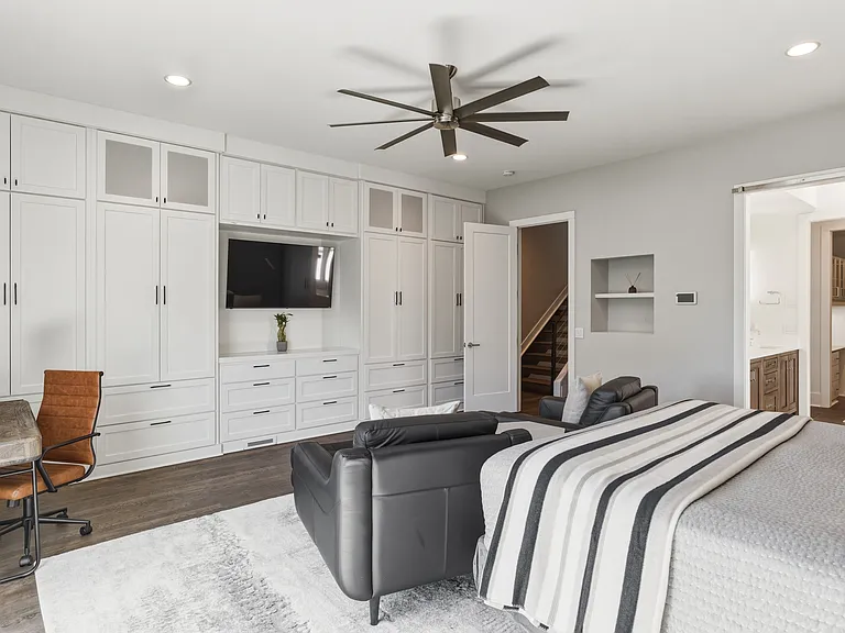 Spacious primary suite featuring a plush king bed, cozy seating area, walk-in closet with custom built-ins, spa-like bath, smart TV and private access to an 11x9 deck. Your private retreat to unwind in comfort.