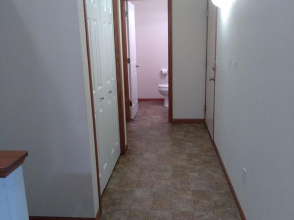 Hall with nook to 1st floor bath, garage, and utility room.