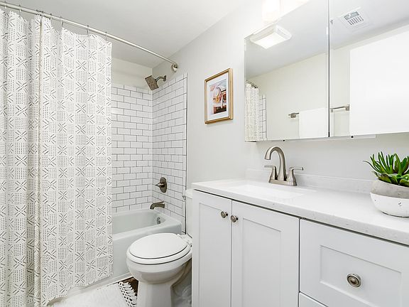 remodeled bath with new subway tile in shower, new vanity, light fixture and medicine cabinet