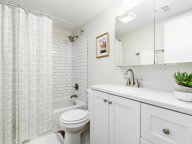 remodeled bath with new subway tile in shower, new vanity, light fixture and medicine cabinet