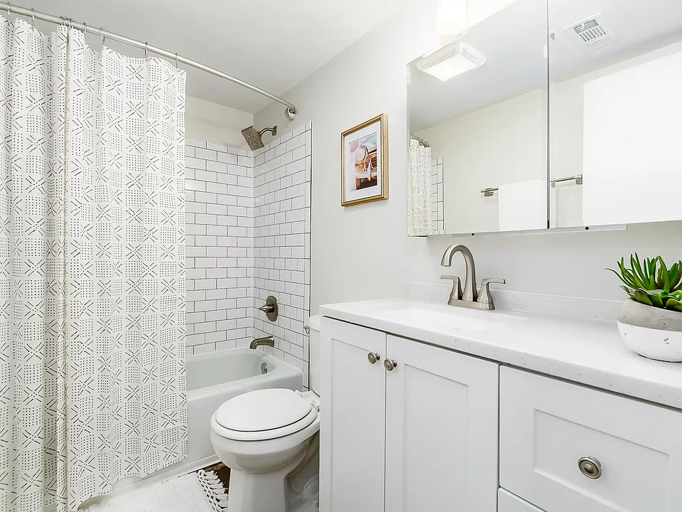 remodeled bath with new subway tile in shower, new vanity, light fixture and medicine cabinet