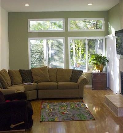 A spacious living room with a wall of windows, a glass slider from the living 