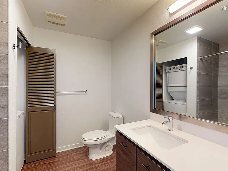 Apartment Bathroom with large soaking tub and Wood-Style Flooring.