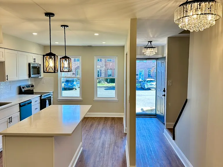 Bright, modern kitchen with brand-new stainless steel appliances, a large center island, and oversized windows bringing in incredible natural light_creating an inviting space to cook, gather, and entertain.