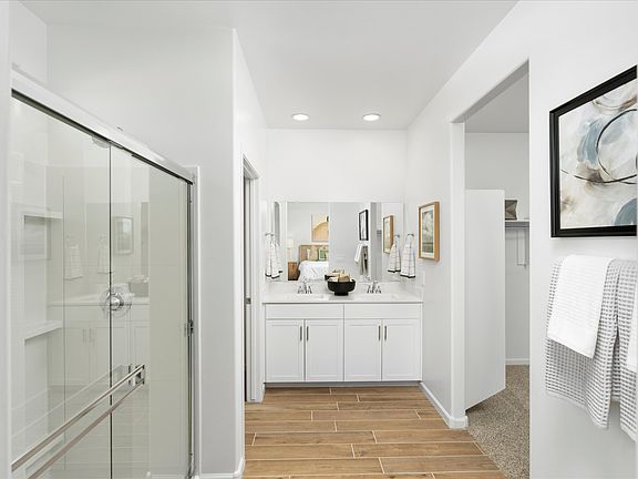 The primary bathroom features dual sinks and a walk-in closet with plenty of storage.