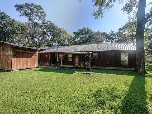A view from the backyard of the cute back porch and one of the great storage buildings.