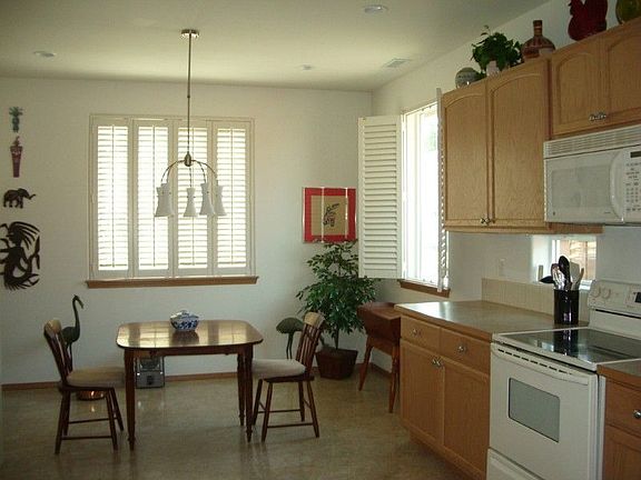Notice the beautiful white plantation shutters, oak cabinets and laminate countertops with tile back
