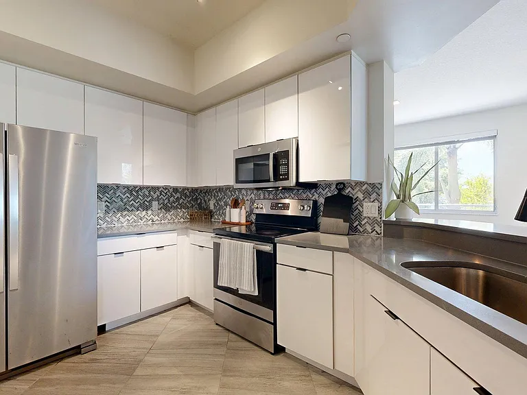 Apartment Kitchen with Granite counter tops and Wood-Style Flooring.