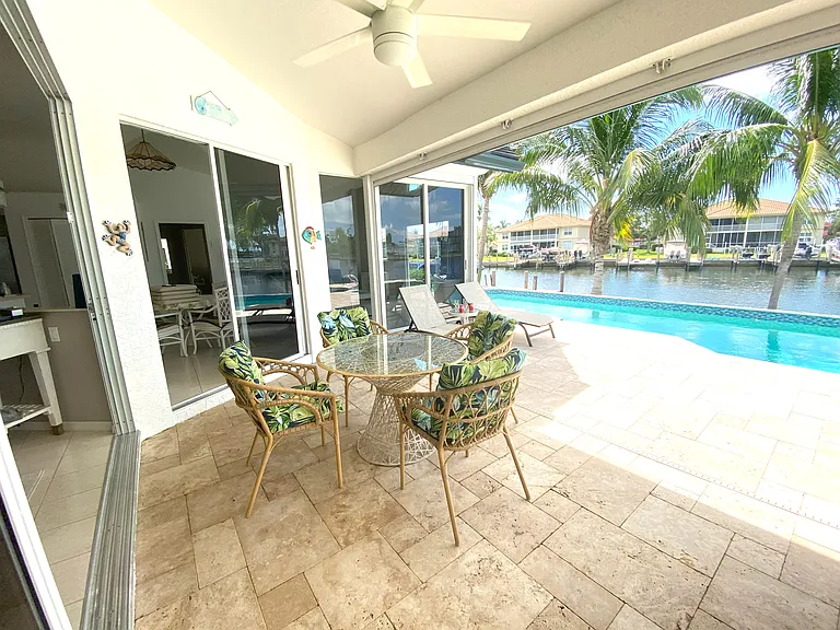 Comfortable garden furniture, outdoor garden table under the covered terrace to share a meal with family or friends