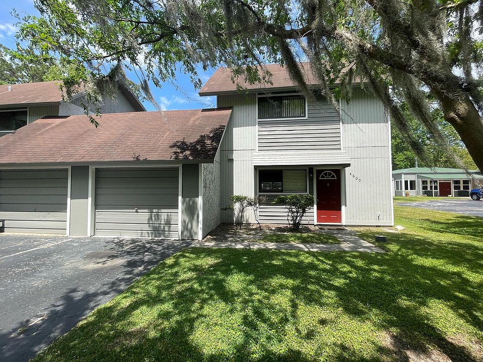 Front of home showing attached one car garage, end unit, and extra parking
