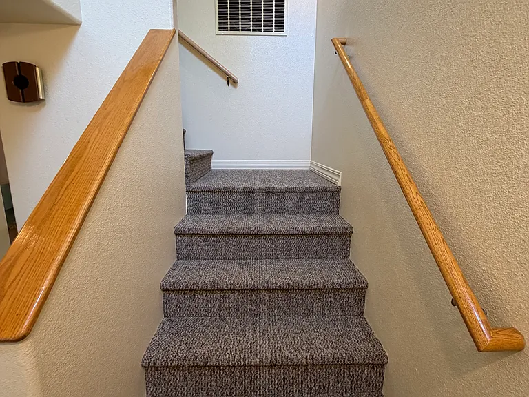Stairs leading from the front door to the three upstairs bedrooms.