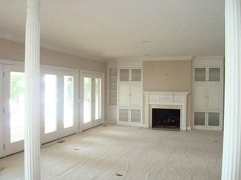Living room with a fireplace and lots of windows to enjoy th