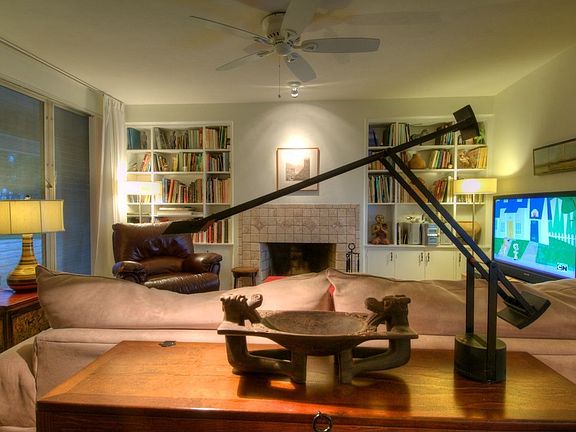 Cozy living room with bookshelves is wired for all forms of entertainment