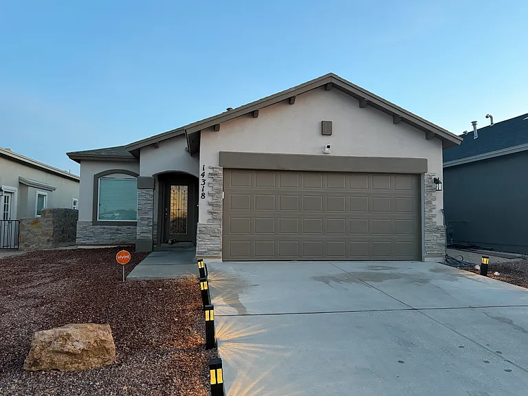 Welcoming front elevation with contemporary finishes, a two-car garage, and low-maintenance landscaping.