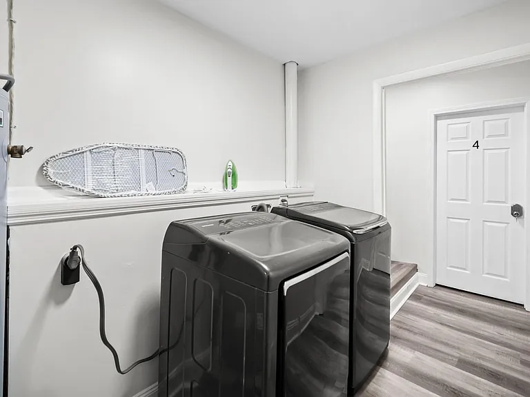 Dedicated laundry area with full-size washer and dryer, durable flooring, and convenient access near the interior door.
