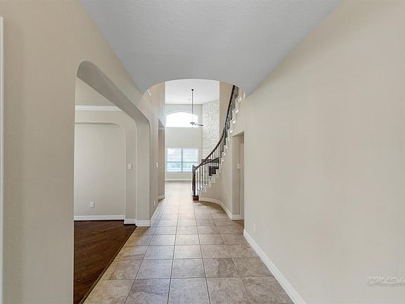 Wide hallway entry with study and dining rooms on your left.  Tile flooring flows into the living room and kitchen area.