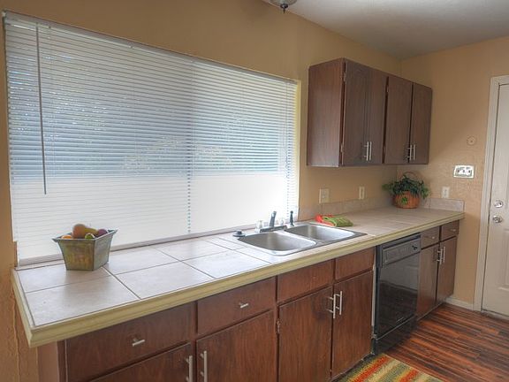 Tile countertops & large window overlooking backyard
