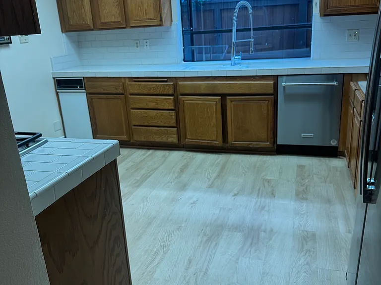Kitchen with new floors and dishwasher and fridge