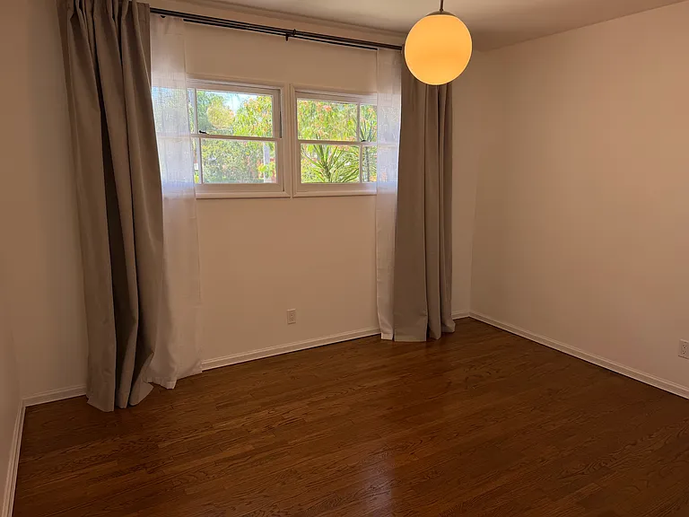 Front bedroom with blackout curtains and sheer curtains.
