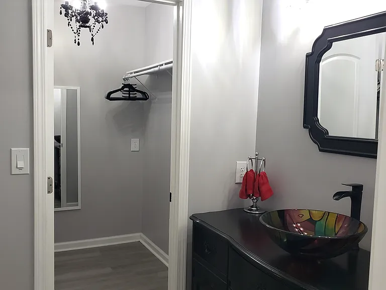 The large walk-in closet offers a lovely chandelier and plenty of storage with shelving.