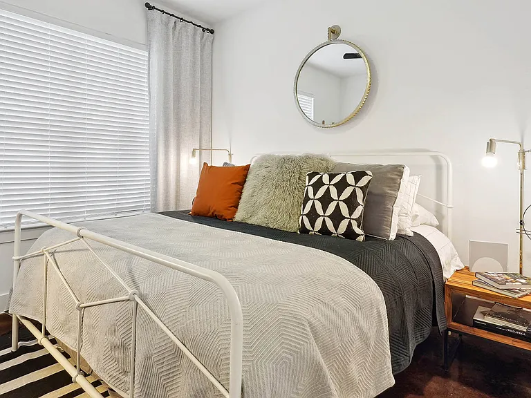 Spacious apartment bedroom with wood-style flooring.