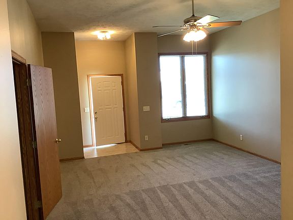 View of front door, entry, door to basement, and living room.