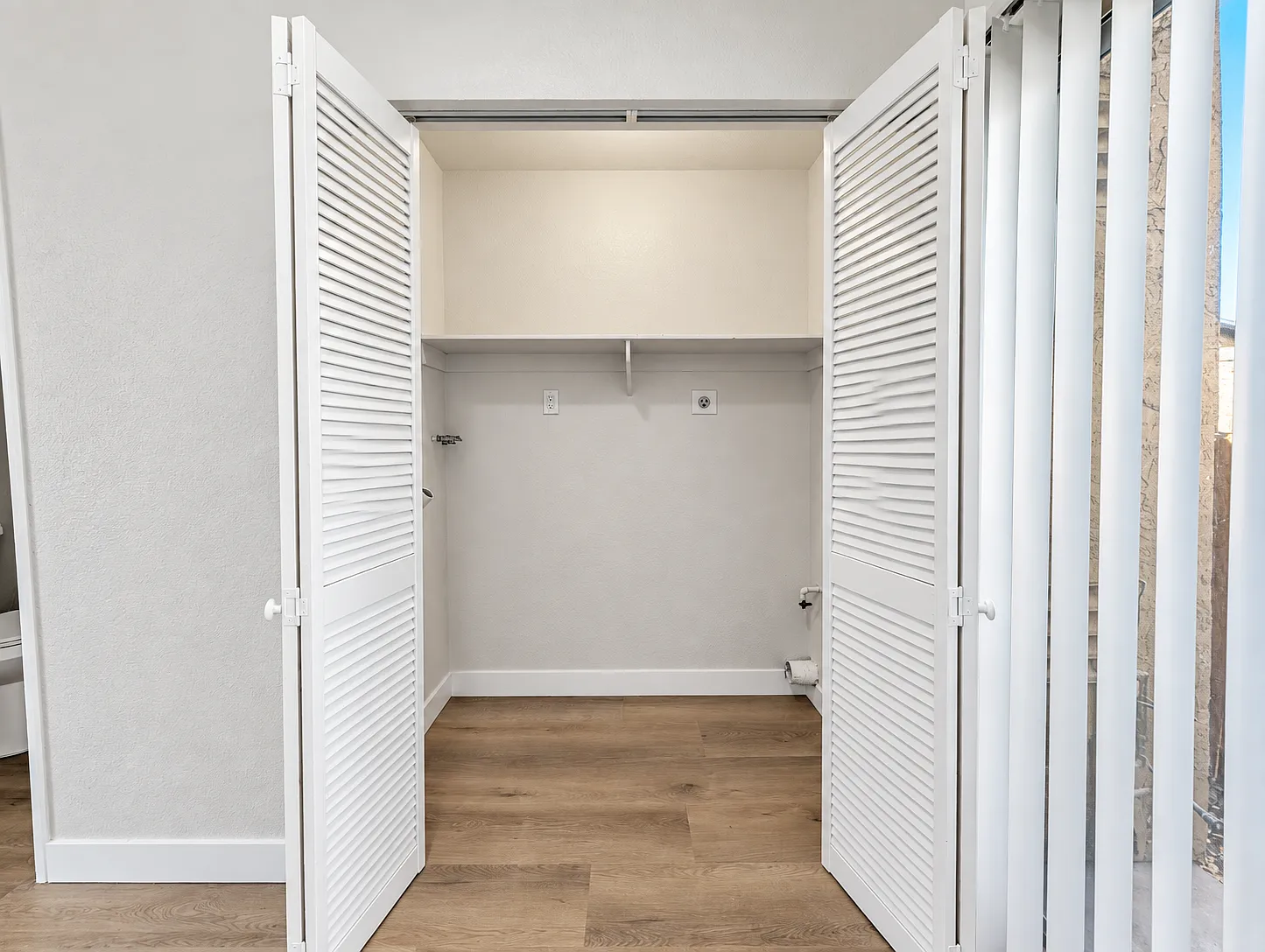 Laundry closet in kitchen with washer and dryer hook ups.
