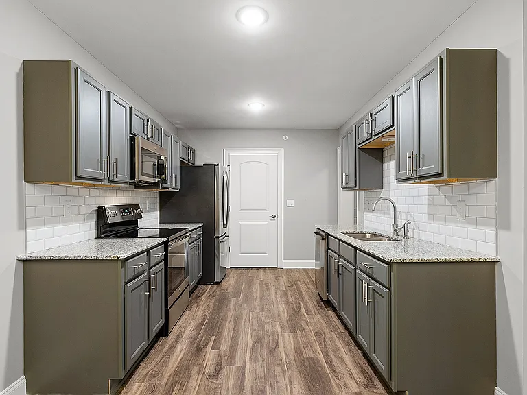 Sleek modern kitchen featuring elegant grey cabinetry, stainless steel appliances, and stylish wood flooring.
